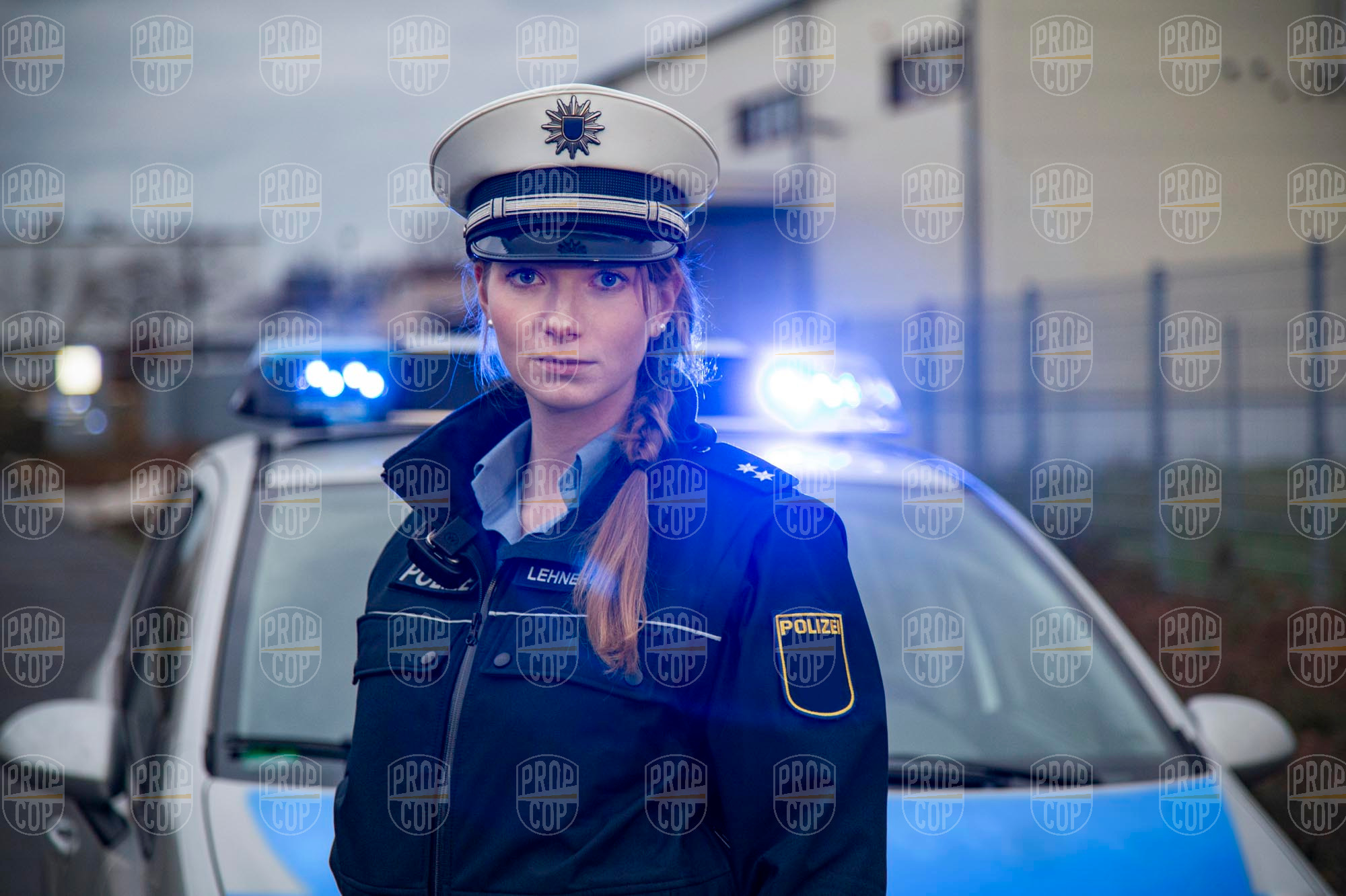 Polizistin in Uniform vor Streifenwagen