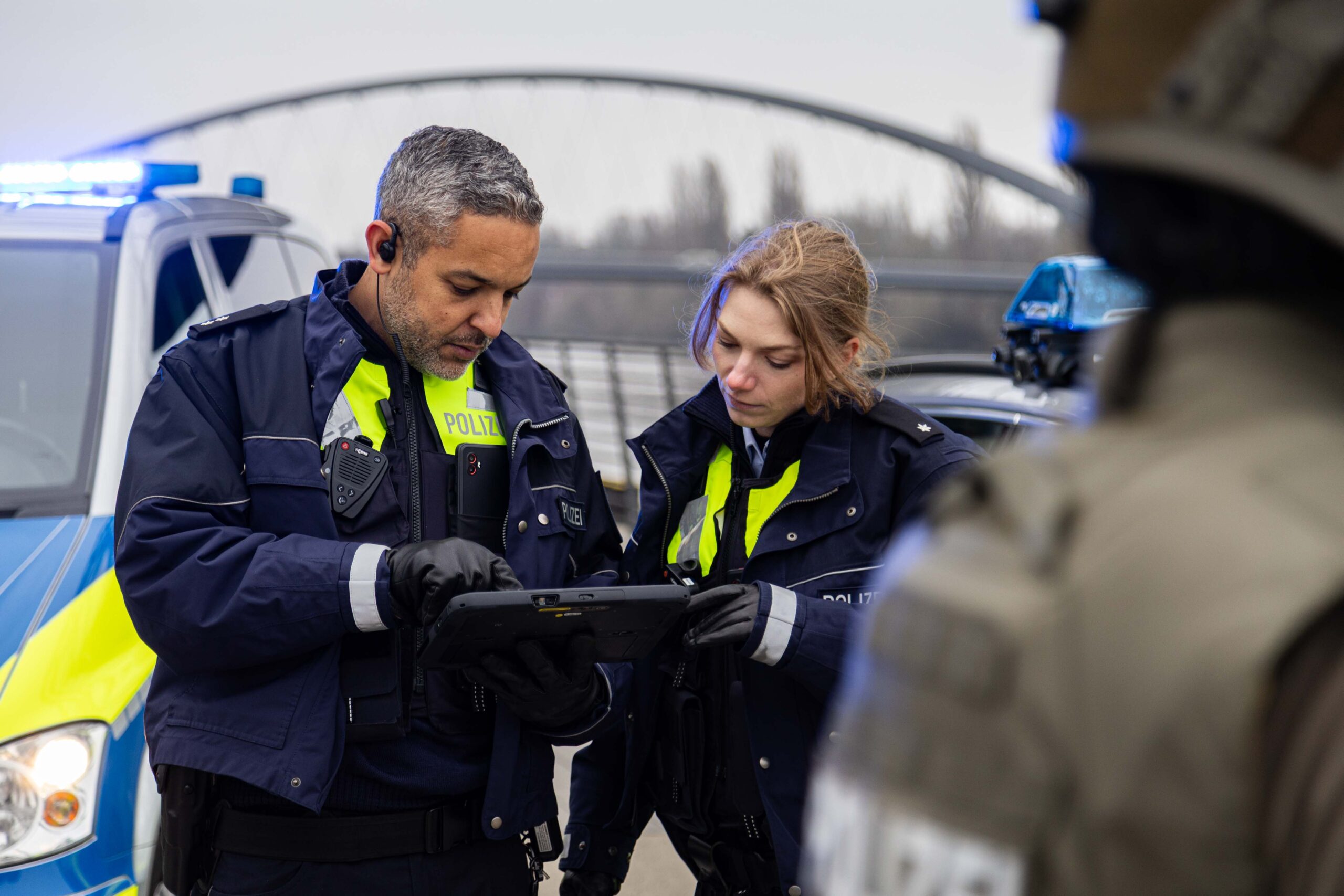 Authentische Polizeiuniformen für Film & TV Produktionen, Werbung und Social Media Polizisten bei einem Filmdreh schauen auf einen Monitor